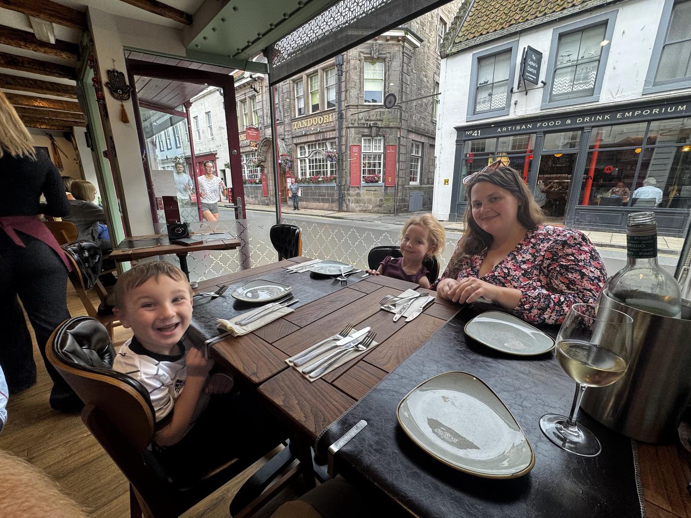 Two children and a grown-up at a restaurant table by the window on Bridge Street, Berwick.